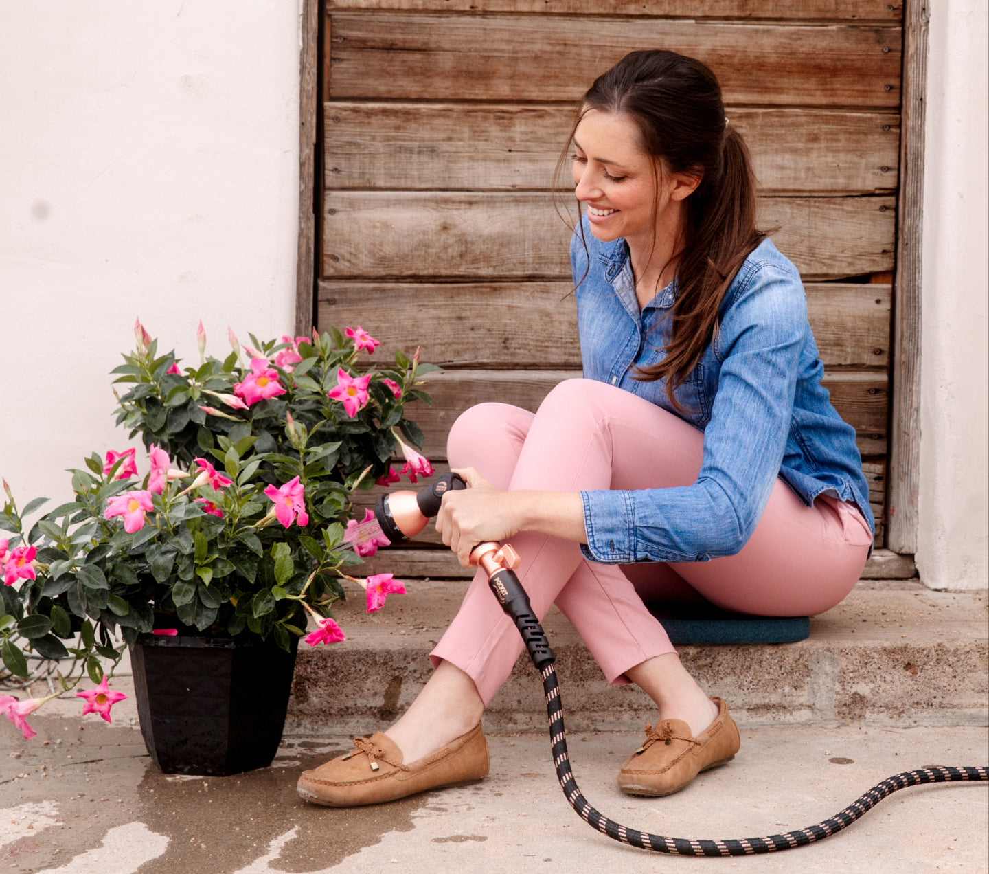 Woman watering flowers with Copper Bullet and Thumb Drive Nozzle