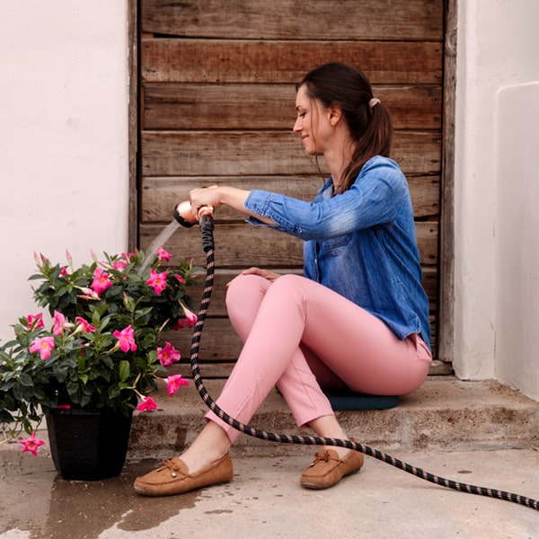 Pocket Hose Copper Bullet in use by woman watering potted flowers